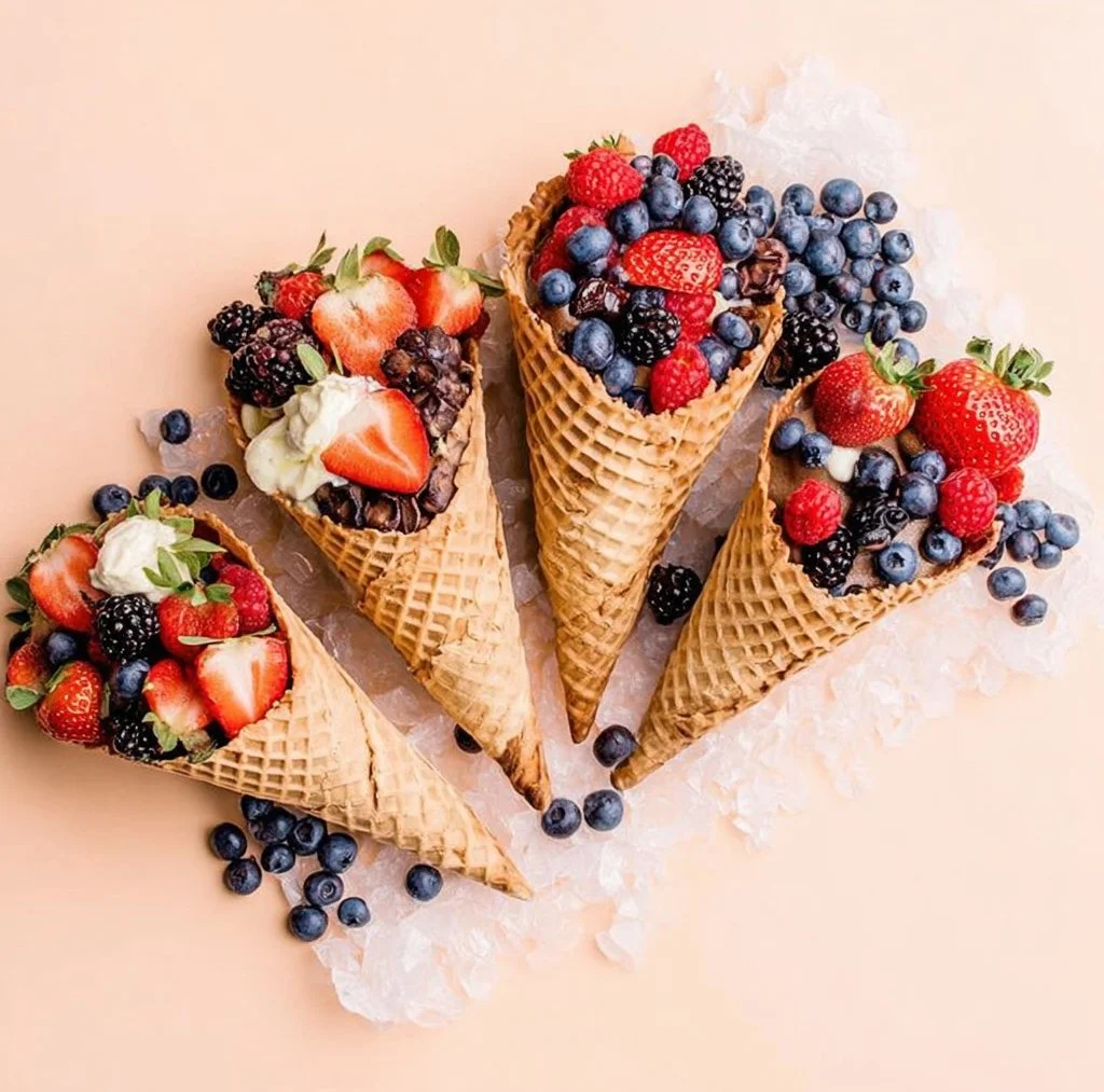 Colorful healthy fruit cones filled with fresh fruits and yogurt.