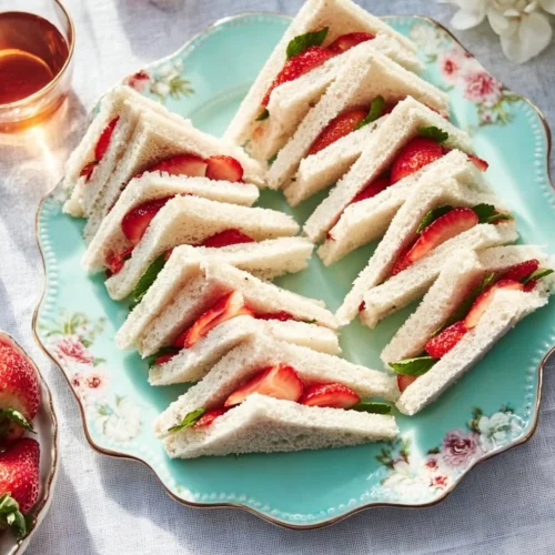 Strawberry tea sandwiches arranged on a plate for afternoon tea.